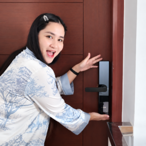 Person presenting a smart lock installed on a wooden door