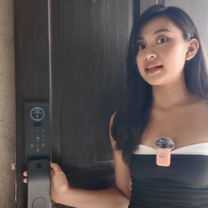 Person demonstrating a LOOCK smart lock installed on a wooden door
